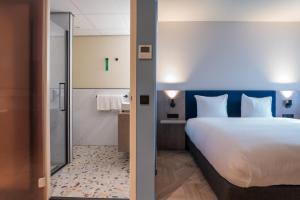 Postel nebo postele na pokoji v ubytování Golden Tulip Leiden Centre