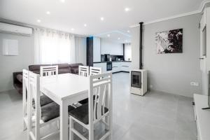 une cuisine et un salon avec une table et des chaises blanches dans l'établissement Casa Olivia with pool heating fee, à Torrevieja