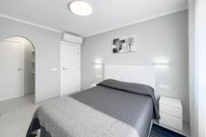 une chambre avec un lit dans une pièce blanche dans l'établissement Casa Olivia with pool heating fee, à Torrevieja