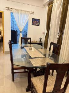 a dining room with a glass table and chairs at VANDYaS INN 1BHK Studio Unit in Guwahati +9 photos