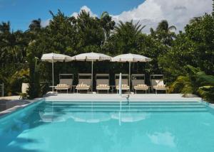 a swimming pool with chairs and umbrellas at La Concha in West Bay