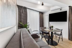 a living room with a couch and a table at Sea Reflections in Infinity Pool & Spa Resort in Mamaia Sat/Năvodari +74 photos