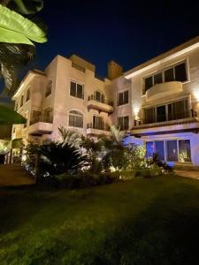 a large white building with lights in front of it at One Sixteen Guest House in Sheikh Zayed