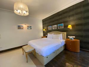 a bedroom with a bed and a chair and a chandelier at One Sixteen Guest House in Sheikh Zayed +24 photos