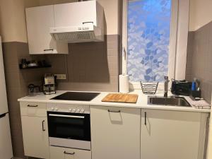 une cuisine blanche avec un évier et une cuisinière dans l'établissement City-Apartment im Herzen von Graz T14, à Graz