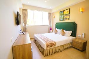 a hotel room with a bed and a window at Hotel Flora in Male City