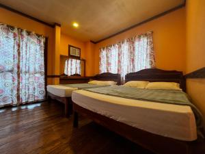 Giường trong phòng chung tại VisiTours Nook Moalboal Guest House