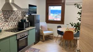 a kitchen with a table and a refrigerator and a dining room at Etea-Vigo in Vigo