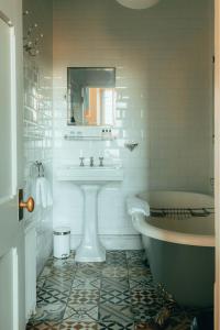 a white bathroom with a sink and a tub at The Rudloe Near Bath - Marco Pierre White in Corsham +47 photos