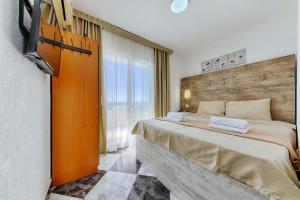 a bedroom with a bed and a large window at Studio Apartments S in Dobra Voda