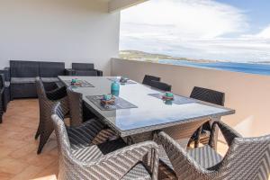 a dining room with a table and chairs and the ocean at VivimiHome - Villa Sos Aranzos in Isola di Porticciuolo