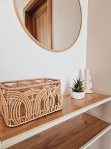 a wicker basket sitting on a wooden shelf with a mirror at Apartament Gniezno Bulwary 7a in Gniezno +34 photos