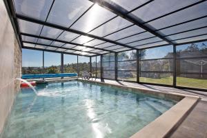 an indoor swimming pool with a retractable roof at Villa Mila Piscina e Jacuzzi in Salir de Matos