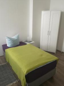 a bedroom with a green bed and a white cabinet at FeWo Vermietung Plauen in Plauen