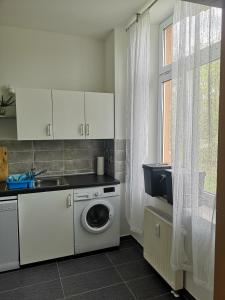 a kitchen with a washing machine and a window at FeWo Vermietung Plauen in Plauen