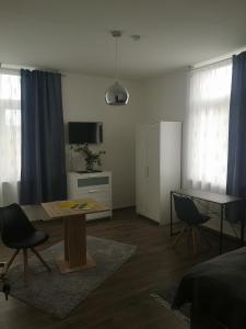 a living room with a table and chairs and a television at FeWo Vermietung Plauen in Plauen +8 photos