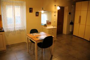 eine Küche mit einem Holztisch und zwei Stühlen in der Unterkunft La Casa del Sole a Cosy Nest in Lunigiana, Tuscany in Giucano