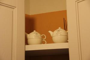 zwei Teekannen auf einem Regal in einem Schrank in der Unterkunft La Casa del Sole a Cosy Nest in Lunigiana, Tuscany in Giucano