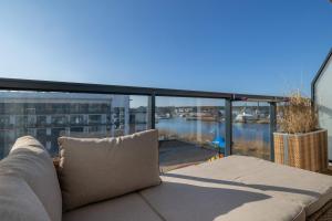 a couch on a balcony with a view of the water at Cozy Studio with River View Spadochroniarzy with Parking & SPA by Noclegi Renters in Dziwnów