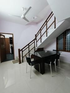 a dining room with a black table and chairs at Volare villa in Cochin