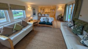 ein Wohnzimmer mit zwei Sofas und einem Tisch in der Unterkunft Stunning New Forest Country House - Abbot's Well for up to 10 guests in Godshill
