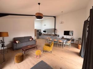 una sala de estar con un sofá y una mesa en Le Domaine de la Haye - Gîtes, en Saint-Christophe-du-Bois