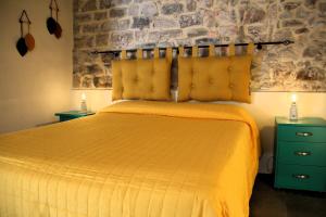 ein Schlafzimmer mit einem gelben Bett mit zwei Nachttischen in der Unterkunft La Casa del Sole a Cosy Nest in Lunigiana, Tuscany in Giucano + 20 Fotos