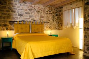 ein Schlafzimmer mit einem Bett mit gelber Tagesdecke in der Unterkunft La Casa del Sole a Cosy Nest in Lunigiana, Tuscany in Giucano