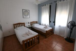 zwei Betten in einem kleinen Zimmer mit Fenster in der Unterkunft Villa Ostria - by Rentals Pro Nea Moudania in Nea Moudania
