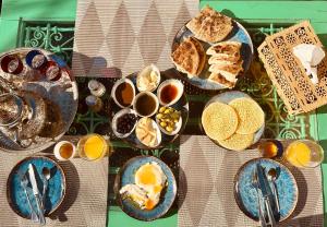 un tavolo con piatti per la colazione e tazze di caffè di 66 Dar Aarab - Marrakech a Marrakech