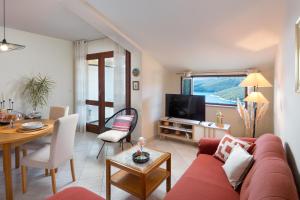 a living room with a red couch and a table at Apartment Roce in Rabac