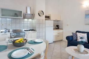 a kitchen and dining room with a table and a room with at Apartment Roce in Rabac