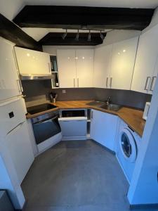纳沙泰尔Appartement hyper centre de Neuchâtel tout confort的厨房配有白色橱柜和洗衣机。 更多6张照片