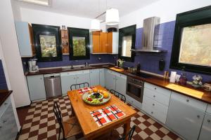 eine Küche mit einem Tisch mit einer Obstschale darauf in der Unterkunft Villa Ostria - by Rentals Pro Nea Moudania in Nea Moudania + 21 Fotos