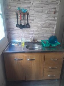 la milonga في أتلانتيدا: طاولة مطبخ مع حوض وجدار حجري