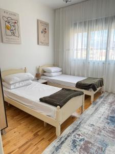 a bedroom with two beds and a window at Sol Apartment - 2 Bedrooms in Shkodër