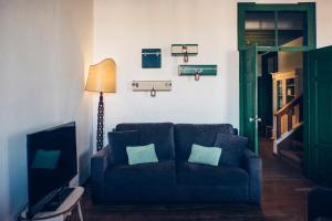 a living room with a blue couch and a lamp at Boutique Taghostel in Lagos