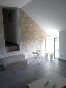 sala de estar con escaleras y pared de piedra en La Gagère, maison de campagne berrichonne, en Azy