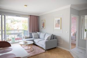 a living room with a couch and a table at Rose Gold by Go Apart in Gdańsk