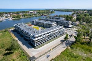 an aerial view of a large building next to a river at Cozy Studio with River View Spadochroniarzy with Parking & SPA by Noclegi Renters in Dziwnów +29 photos