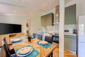 a kitchen with a wooden table and a dining room at Le Casenave - Very quiet and comfortable in Chennevières-sur-Marne