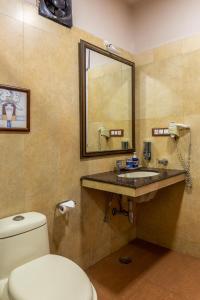 bagno con servizi igienici e lavandino con specchio di IL Palazzo Villas a Panchgani Altre 37 foto