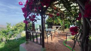 a gazebo with a table and flowers at The Good Vibes Home in Hoya de Pineda