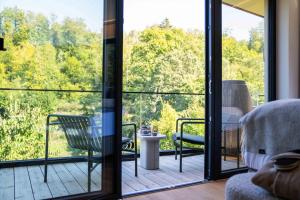 a room with a balcony with a view of trees at Hotel & Spa Suiten FreiWerk in Stolberg