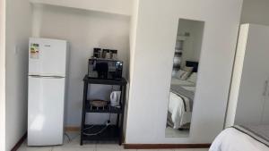 a kitchen with a white refrigerator and a bedroom at MELJAA STAR Guesthouse in Cape Town