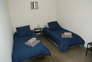 two beds in a room with blue sheets at Le CLOS MARATUEL in Sarlat-la-Canéda