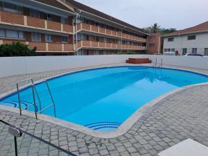 een groot blauw zwembad voor een gebouw bij 7 Kenwyn On Sea in Ballito