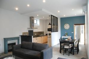 a living room and kitchen with a couch and a table at Le CLOS MARATUEL in Sarlat-la-Canéda