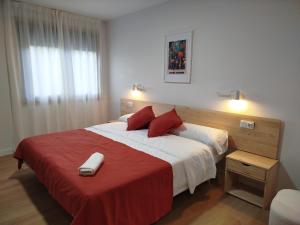 a bedroom with a large bed with a red blanket at Hotel Zura in Seoane +29 photos