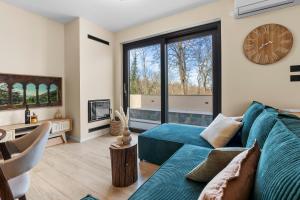 a living room with a blue couch and a large clock at Charming Villa Harmonia with Heated pool and Indoor Jacuzzi surrounded by nature in Pićan